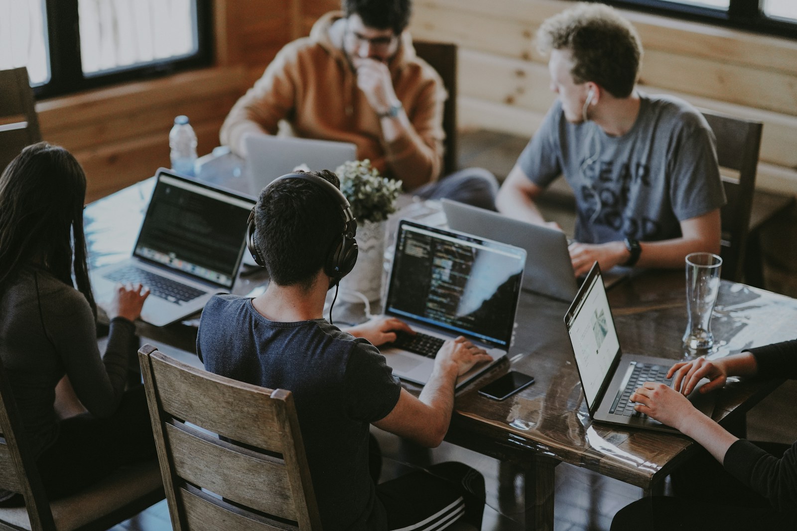 A workplace team collaborating around laptops